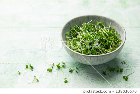 Fresh microgreens in a bowl on wooden surface Fresh microgreens in a bowl on wooden surface 139036576