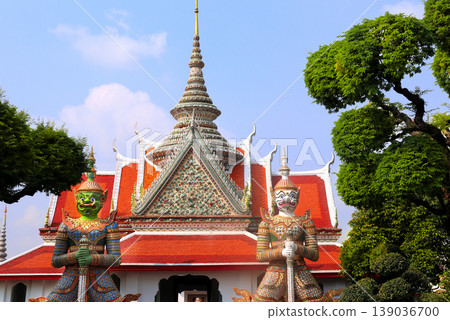 Two Colorful Giant Yaksha statues, guarding the entrance of Buddhist Temple of Dawn Wat Arun, sightseeing landmark of Bangkok, Thailand. Topic of summer vacation, relaxing, travel, trip, cruises, tour 139036700