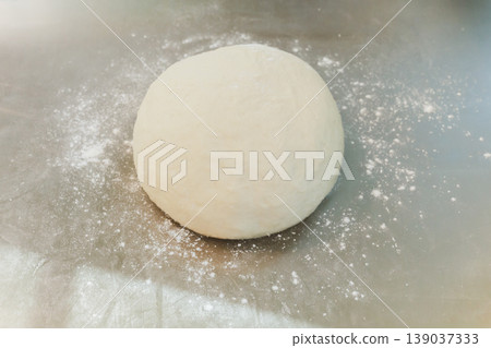 Raw fresh yeast dough ball for bread or pizza in kitchen counter with flour dust. Raw fresh yeast dough ball for bread or pizza in kitchen counter with flour dust. 139037333
