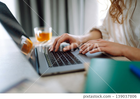 Close-up of woman's hands with modern laptop, studying, taking notes on device. Technology concept. Close-up of woman's hands with modern laptop, studying, taking notes on device. Technology concept. 139037806