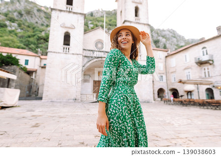 Happy female tourist in beautiful dress walking in the street of the city. Fashion style. 139038603
