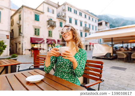 Young woman in a green dress smiles while using her yellow smartphone. Travel, tourism, technology Young woman in a green dress smiles while using her yellow smartphone. Travel, tourism, technology 139038617