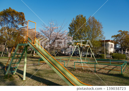 Springtime park playground equipment, swings, slides, and cherry blossoms Springtime park playground equipment, swings, slides, and cherry blossoms 139038723