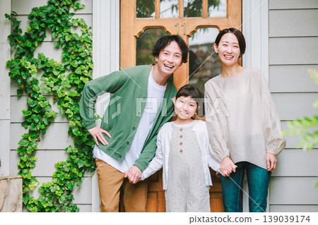 A close-knit family heading out with smiles on their faces. 139039174