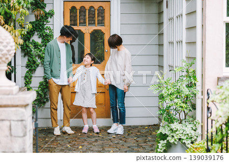 A close-knit family heading out with smiles on their faces. 139039176