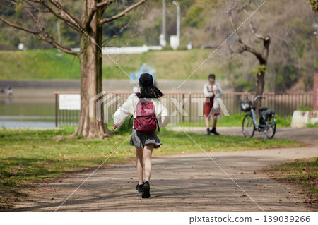 The scene of junior high school girls enjoying cherry blossom viewing in a park full of blooming cherry trees in spring. The scene of junior high school girls enjoying cherry blossom viewing in a park full of blooming cherry trees in spring. 139039266