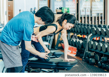 接受重量訓練指示的少婦在健身房 接受重量訓練指示的少婦在健身房 139039613