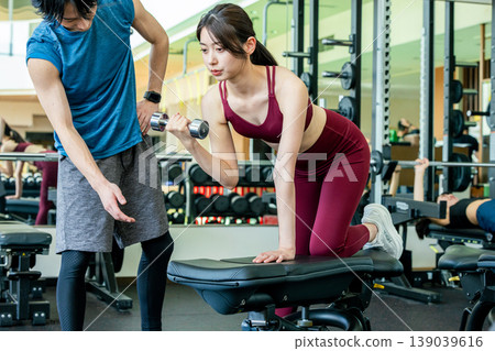 接受重量訓練指示的少婦在健身房 139039616
