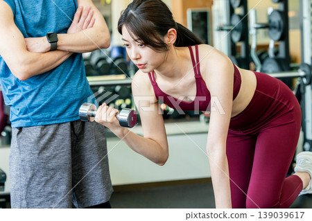 接受重量訓練指示的少婦在健身房 139039617