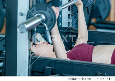 一位女士正在健身房鍛鍊手臂肌肉。 139039618