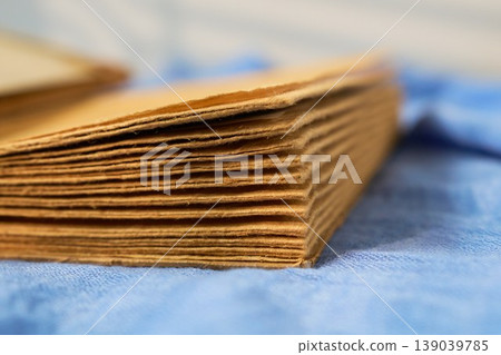 Craftsman paper display. Soft natural illumination showcases tactile quality of handcrafted kraft pages on linen fabric 139039785
