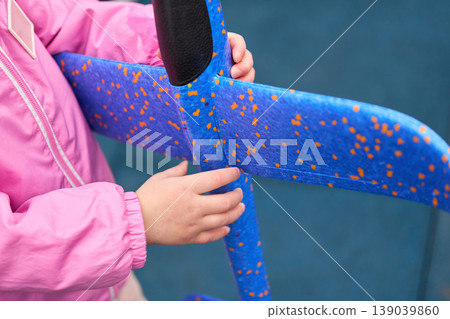 Little child touching colorful upholstery. Young child in vibrant attire explores patterned fabric of public transit seat 139039860