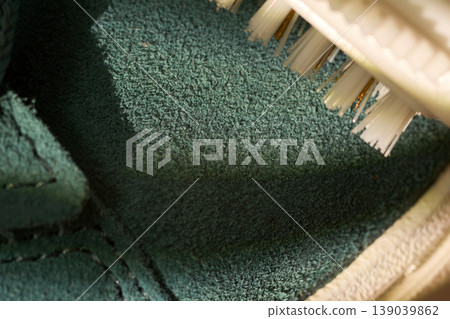 Macro silicone brush texture on sneaker edge, extreme closeup of white ridged head hovering over suede midsole, tactile detail, studio light 139039862