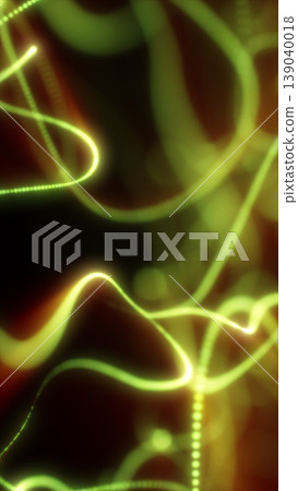 Abstract yellow and green neon light trails twisting through darkness with energetic motion and glowing curves. Abstract yellow and green neon light trails twisting through darkness with energetic motion and glowing curves. 139040018