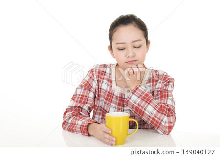 A woman thinking while drinking coffee A woman thinking while drinking coffee 139040127
