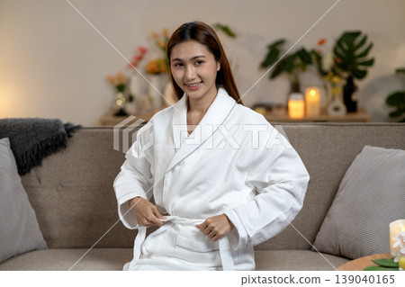 Adult Asian woman tying white bathrobe preparing spa wellness relaxation at home sofa self care routine cozy environment comfort happiness beauty Adult Asian woman tying white bathrobe preparing spa wellness relaxation at home sofa self care routine cozy environment comfort happiness beauty 139040165