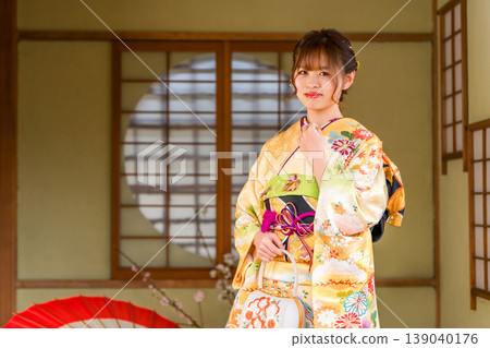 一位身穿振袖和服的日本年輕女子在日式房間(成年禮、20歲生日慶祝) 一位身穿振袖和服的日本年輕女子在日式房間(成年禮、20歲生日慶祝) 139040176