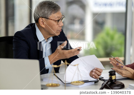 Asian adult man legal professional discusses important documents provides expert advice formal office setting justice symbols Asian adult man legal professional discusses important documents provides expert advice formal office setting justice symbols 139040378