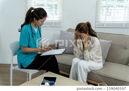 Asian female doctor therapist consults adult patient woman stress anxiety mental health discussion offering support medical advice private clinic home visit 139040397