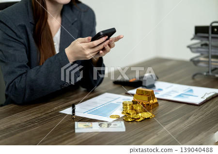 Asian adult woman business professional managing finance using smartphone on office desk for secure investment wealth building and economic growth strategy 139040488