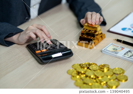 Adult hands calculating finance gold investment wealth management business success strategy future savings profit growth office desk environment 139040495