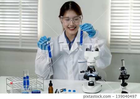 Asian adult female scientist research development holding blue liquid test tubes laboratory discovery innovation experiment success medical chemistry biotechnology science Asian adult female scientist research development holding blue liquid test tubes laboratory discovery innovation experiment success medical chemistry biotechnology science 139040497