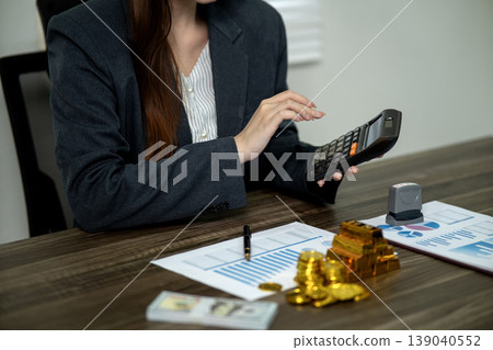 Adult Asian businesswoman professional calculates finance analyzes data for business strategy investment wealth growth at modern office desk workspace Adult Asian businesswoman professional calculates finance analyzes data for business strategy investment wealth growth at modern office desk workspace 139040552
