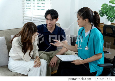 Asian adult couple distressed seek medical consultation empathetic female doctor provides mental health support relationship guidance at modern home environment Asian adult couple distressed seek medical consultation empathetic female doctor provides mental health support relationship guidance at modern home environment 139040579
