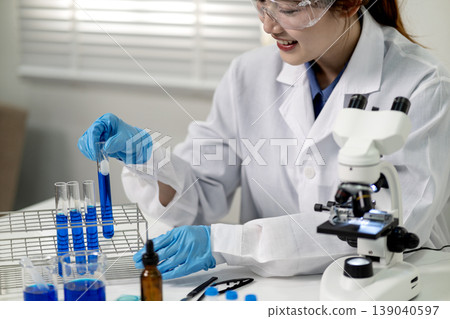Asian woman scientist conduct lab experiment chemistry research test tube analysis microscope discovery innovation medicine health development 139040597