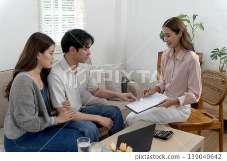 Asian couple discussing document with financial advisor at home office for agreement planning investment property loan insurance service Asian couple discussing document with financial advisor at home office for agreement planning investment property loan insurance service 139040642
