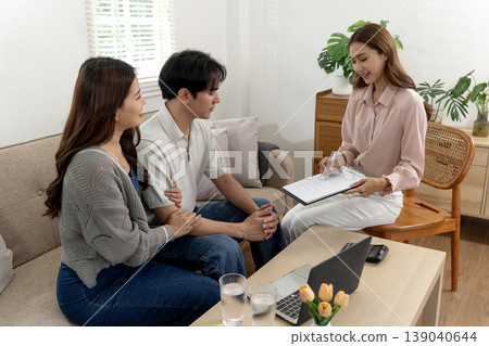 Adult Asian couple consults professional financial advisor about investment opportunities home office setting discussing finance future planning goals Adult Asian couple consults professional financial advisor about investment opportunities home office setting discussing finance future planning goals 139040644