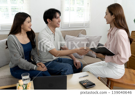 Asian adult couple meet professional advisor at home discuss finance planning real estate purchase handshake agreement Asian adult couple meet professional advisor at home discuss finance planning real estate purchase handshake agreement 139040646