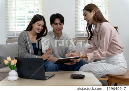Asian adult couple meets financial advisor at home discussing personal finance real estate property investment planning future contract signing Asian adult couple meets financial advisor at home discussing personal finance real estate property investment planning future contract signing 139040647