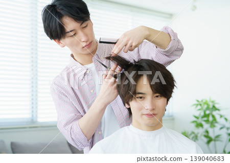 一位年輕的日本理髮師正在剪頭髮 一位年輕的日本理髮師正在剪頭髮 139040683
