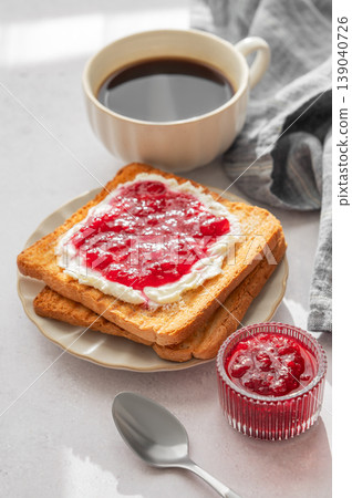 Toast with sweet berry-fruit jam and cream cheese on a plate on a light concrete background Toast with sweet berry-fruit jam and cream cheese on a plate on a light concrete background 139040726