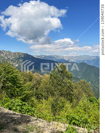 Green mountains with trees and fresh grass under cloudy sky. Natural landscape concept, summer day Green mountains with trees and fresh grass under cloudy sky. Natural landscape concept, summer day 139040738