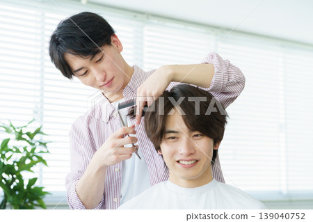 A young Japanese hairdresser cutting hair 139040752