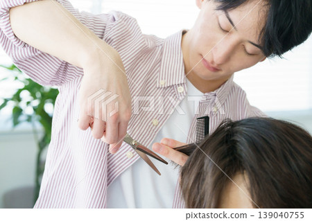 一位年輕的日本理髮師正在剪頭髮 一位年輕的日本理髮師正在剪頭髮 139040755