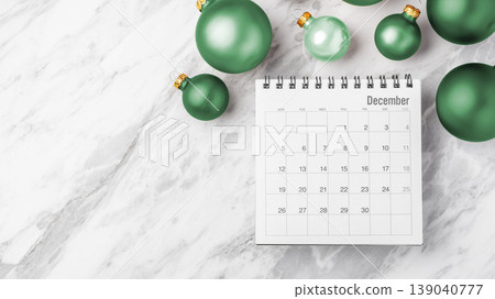 Calendar with green Christmas ball on white marble background, December holiday planning, copy space Calendar with green Christmas ball on white marble background, December holiday planning, copy space 139040777