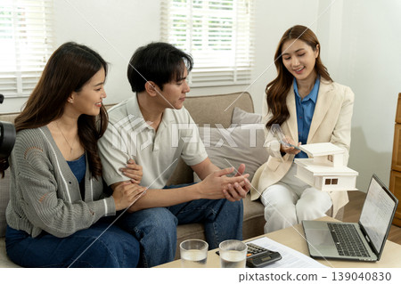 Asian couple consults real estate agent for home purchase property investment modern living house model presentation mortgage financial planning future house buyers Asian couple consults real estate agent for home purchase property investment modern living house model presentation mortgage financial planning future house buyers 139040830
