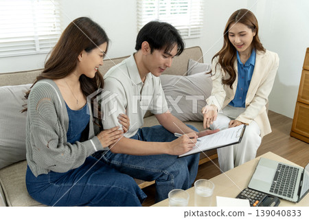 Asian adult couple meeting financial advisor signing important contract agreement home office setting discussing future plans investment property insurance documents 139040833