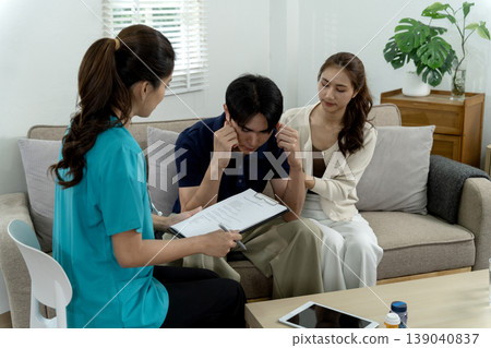 Asian healthcare professional discussing mental health issues with adult Asian couple providing support during therapy session home clinic Asian healthcare professional discussing mental health issues with adult Asian couple providing support during therapy session home clinic 139040837