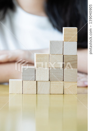Wooden blocks rising steps child behind patience effort planning strategy step progress focus control consistency logical development achievement. 139040905