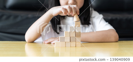 Wooden blocks rising steps child behind patience effort planning strategy step progress focus control consistency logical development achievement. 139040909
