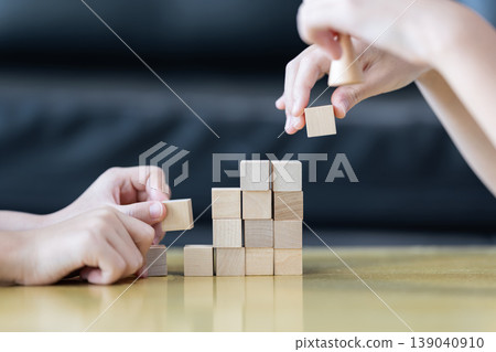 Wooden blocks rising steps child behind patience effort planning strategy step progress focus control consistency logical development achievement. Wooden blocks rising steps child behind patience effort planning strategy step progress focus control consistency logical development achievement. 139040910