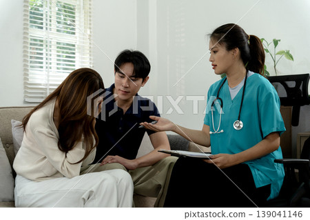Asian adult couple therapy session receive emotional support professional guidance female doctor counselor comfortable private setting discuss mental health relationship issues 139041146