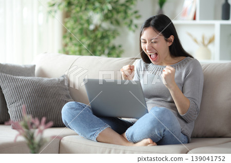 Excited asian woman celebrating checking computer 139041752
