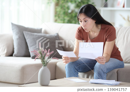 Surprised asian woman reading smazing letter Surprised asian woman reading smazing letter 139041757