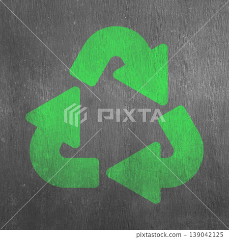 A vibrant green universal recycling symbol on a dark, rough-textured gray surface, representing environmental sustainability, waste reduction, and eco-friendly practices 139042125