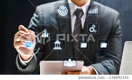 A businessman in a suit interacts with a futuristic digital interface featuring AI, data management, and growth icons to optimize business performance and strategy A businessman in a suit interacts with a futuristic digital interface featuring AI, data management, and growth icons to optimize business performance and strategy 139042141